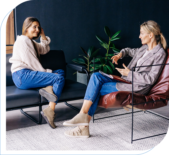 Two women talking on modern chairs.